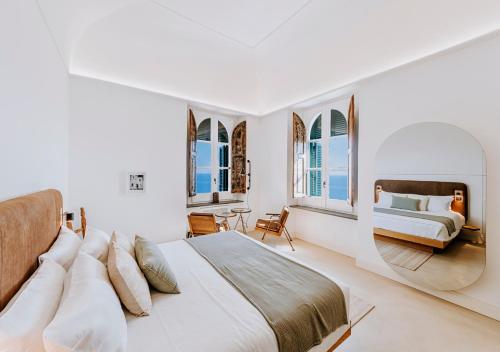 a white bedroom with a bed and a couch at Faro Punta Imperatore in Ischia