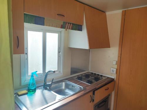 a small kitchen with a sink and a window at MOBIL GALA in Alhaurín de la Torre
