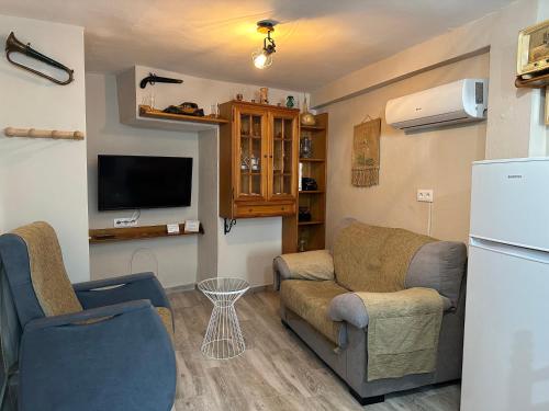 ein Wohnzimmer mit 2 Stühlen und einem Kühlschrank in der Unterkunft Casa Angel in Cazorla