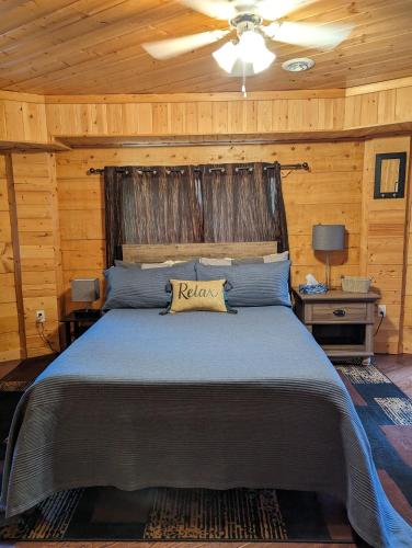 1 dormitorio con 1 cama grande y pared de madera en Sundance Country Lodge B&B en Marlboro