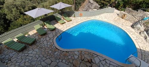 una vista aérea de una piscina con sillas y sombrillas en Katouna Holidays, en Katouna