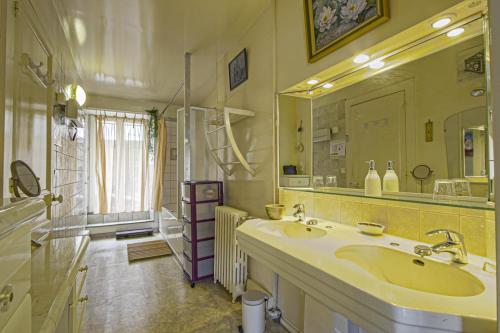 un bagno con due lavandini e un grande specchio di Les Goélands maison avec vue sur port et falaise a Fécamp