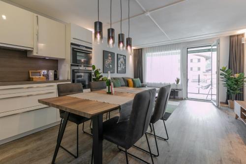 cocina y comedor con mesa y sillas en Spirit Apartments - Suite #1 - Balkon - Bergsicht, en Engelberg
