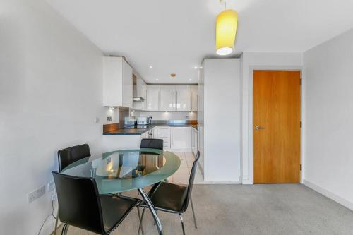 a dining room with a glass table and black chairs at COZYCOMFY LUXURY APARTMENT in London