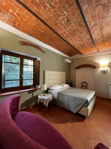 um quarto com uma cama e um sofá em A.G. Rooms in casa colonica em Vaiano
