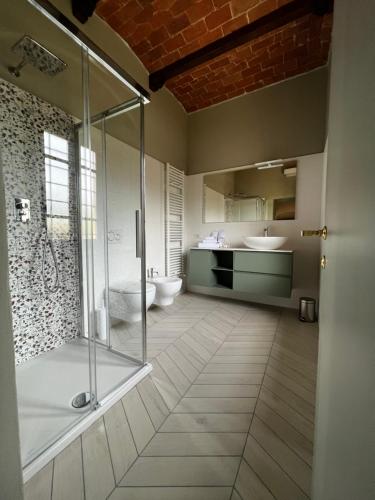 uma casa de banho com uma cabina de duche em vidro e 2 lavatórios. em A.G. Rooms in casa colonica em Vaiano
