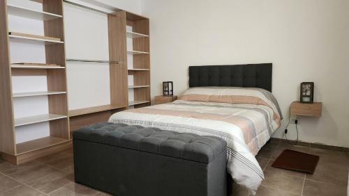 1 dormitorio con 1 cama con reposapiés negro en Caminos del vino !!!!, en Coquimbito