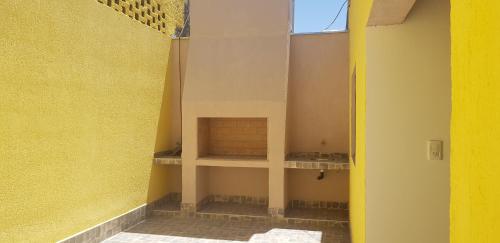 una habitación vacía con una pared amarilla y una ventana en Caminos del vino !!!!, en Coquimbito