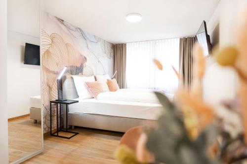 1 dormitorio con cama blanca y ventana en House of Blooms en Fulda