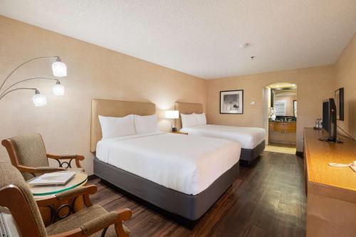 a large hotel room with two beds and a desk at Best Western Plus Las Brisas Hotel in Palm Springs