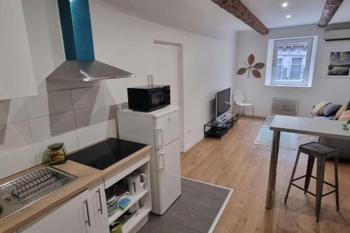 une cuisine avec un évier et une cuisinière four supérieur dans l'établissement T2 au cœur du centre ville de marseille, à Marseille