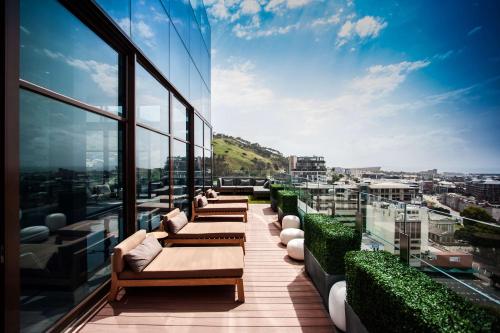 a balcony with couches and a view of a city at SunSquare Cape Town City Bowl in Cape Town