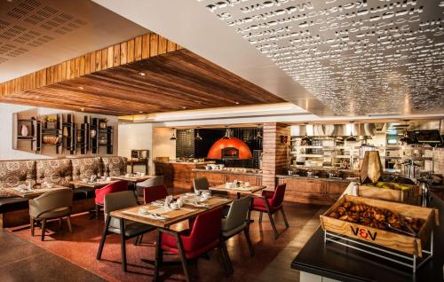 a restaurant with tables and chairs and a bar at SunSquare Cape Town City Bowl in Cape Town
