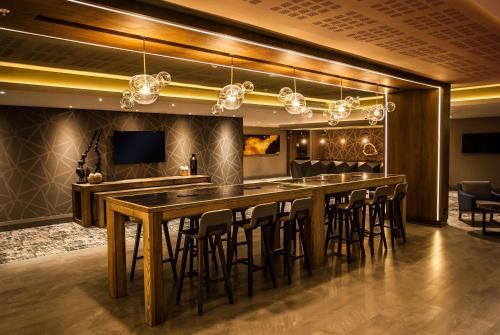 a bar in a room with chairs and a bar table at SunSquare Cape Town City Bowl in Cape Town