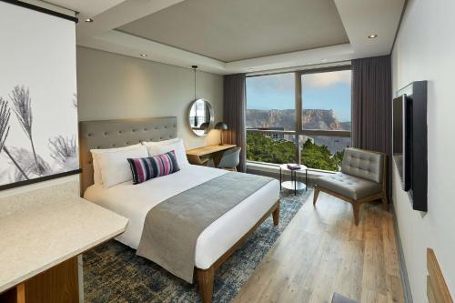 a hotel room with a bed and a window at SunSquare Cape Town City Bowl in Cape Town