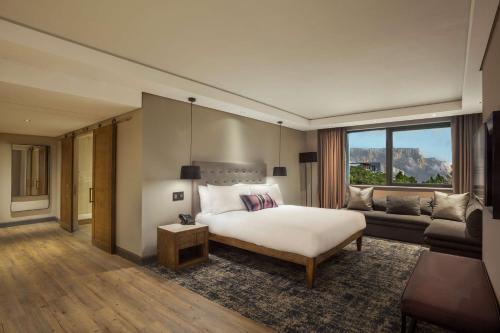 a hotel room with a bed and a couch at SunSquare Cape Town City Bowl in Cape Town