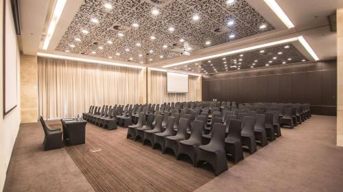 a conference room with chairs and a screen in it at Andersia Hotel & Spa Poznan, a member of Radisson Individuals in Poznań