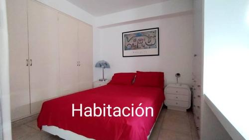 Cama roja en habitación blanca con manta roja en Contemporary, en Caracas