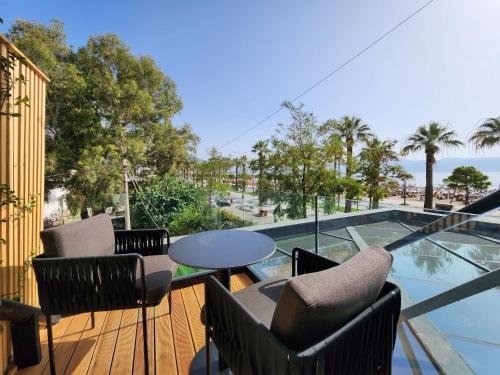 a balcony with chairs and a table and a view of the ocean at Charm Hotel in Vlorë