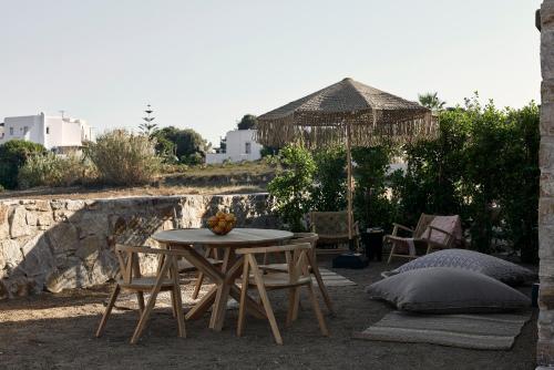 a patio with a table and chairs and an umbrella at Naxian Rhapsody in Stelida