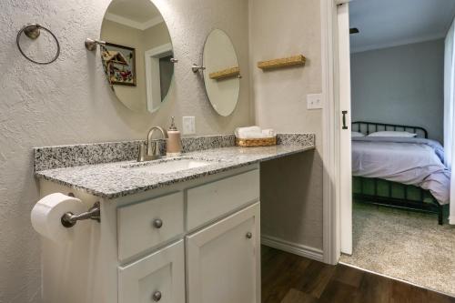 uma casa de banho com um lavatório, um espelho e uma cama em Casino Cottage Getaway 4 Mi to Choctaw Casino! em Durant