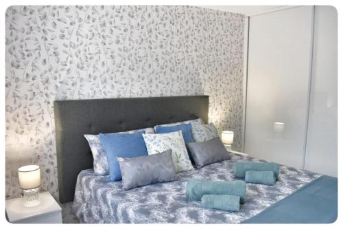 a bedroom with a large bed with blue pillows at Ke Casetta Tenerife Anna Apartment in Adeje