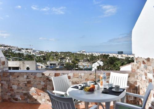 アデへにあるKe Casetta Tenerife Anna Apartmentの景色を望むバルコニー(テーブル、椅子付)