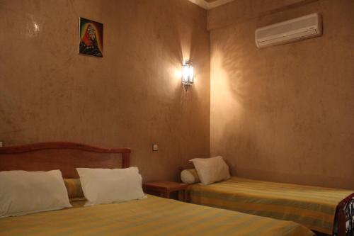 Un pat sau paturi într-o cameră la Dar Lamrani