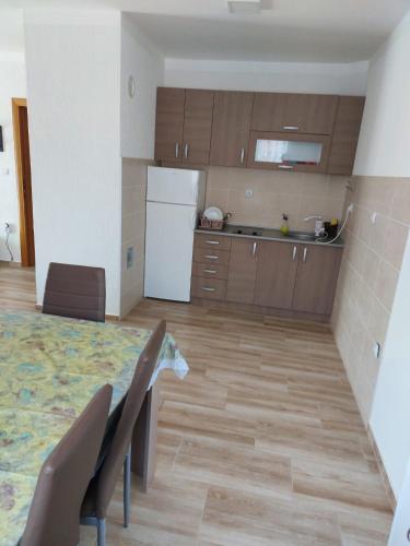 a kitchen with a table and chairs and a refrigerator at Apartmani Milina in Lepterija