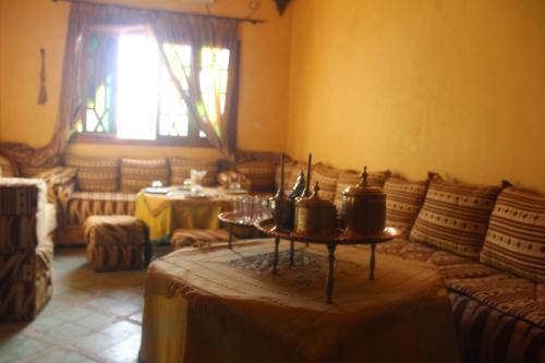 a living room with a table in the middle of it at Dar Lamrani in Rissani