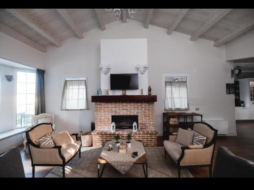 a living room with a fireplace and a tv at Villa Platani Luxury Suite in Cianciana