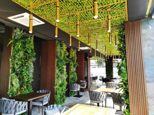 a restaurant with a green wall with tables and chairs at Hotel Kristal Focsani in Focşani