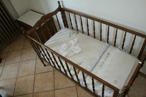 a crib with a white blanket with a bow on it at Agriturismo La Quiete in Roncofreddo