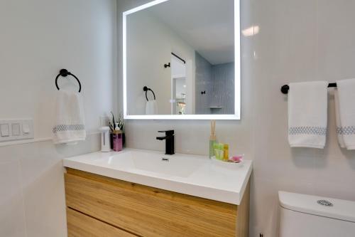 een badkamer met een witte wastafel en een spiegel bij Updated Getaway with Pool and Hot Tub on Less Than 3 Acres! in Stony Point