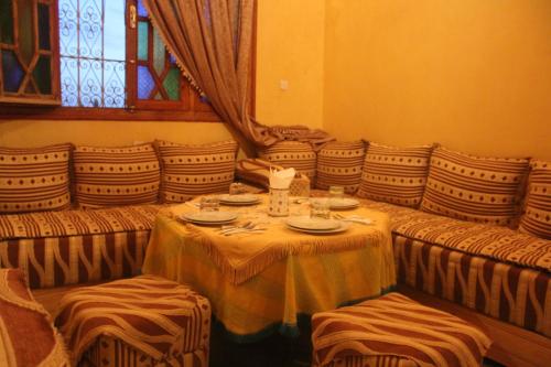 a dining room with a table and chairs and a window at Dar Lamrani in Rissani