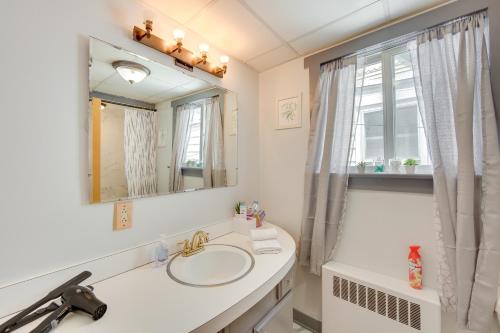 uma casa de banho branca com um lavatório e um espelho em Pet-Friendly Mt Carmel Vacation Rental with Yard! 