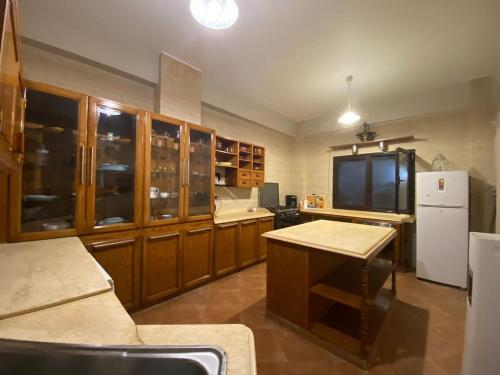 a kitchen with wooden cabinets and a white refrigerator at Bahga villa in Alexandria