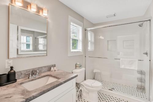 uma casa de banho branca com um lavatório e um WC em Sanford Serenity em St. Augustine