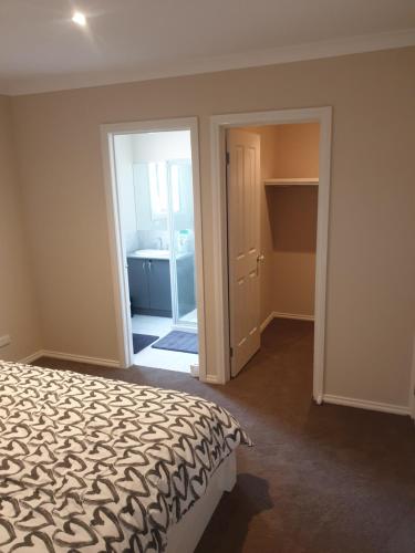 1 dormitorio con cama y armario abierto en Ensuite room with Private Bath toilet CBD Airport en Werribee