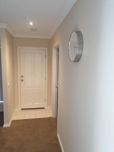 a hallway with a white door and a mirror at Ensuite room with Private Bath toilet CBD Airport in Werribee