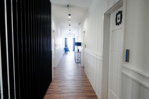 a hallway with white walls and a wooden floor at La Familia TYBURA in Uniejow