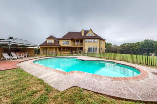 een groot huis met een zwembad in de tuin bij Pueblo Viejo Ranch in Midlothian