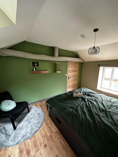 a bedroom with a green wall with a bed and a chair at Le Coin Rocheux in La Roche-en-Ardenne