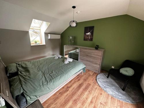 sypialnia z zielonymi ścianami, łóżkiem i krzesłem w obiekcie Le Coin Rocheux w La-Roche-en-Ardenne