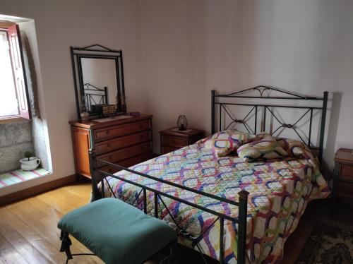 a bedroom with a bed and a dresser and a mirror at Casa do Lagar in Almeida