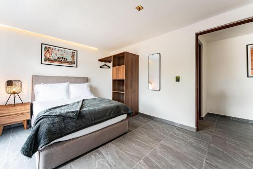 a bedroom with a large bed and a table at Santa Ma la Ribera Apartments by VH in Mexico City