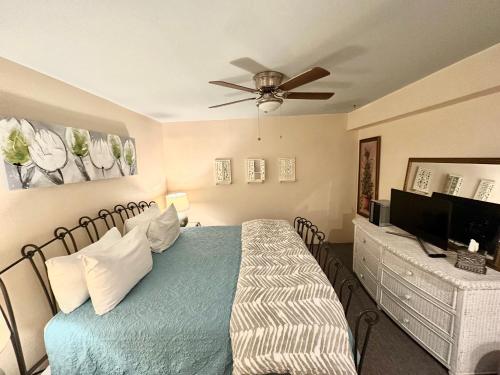 a bedroom with a bed and a ceiling fan at Bisbee Brownstone Suites in Bisbee