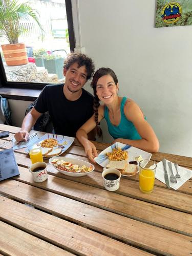 een man en een vrouw zitten aan een tafel en eten bij GREEN DOOR HOSTEL BOUTIQUE in San Gil