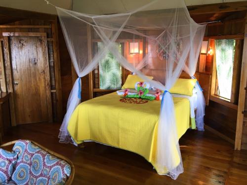a bedroom with a yellow bed with a canopy at Good Hope Retreat in Cave
