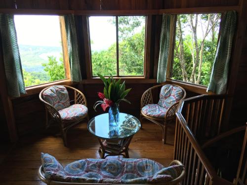 a room with a table and chairs and windows at Good Hope Retreat in Cave